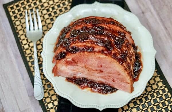 cranberry glazed ham on a white plate